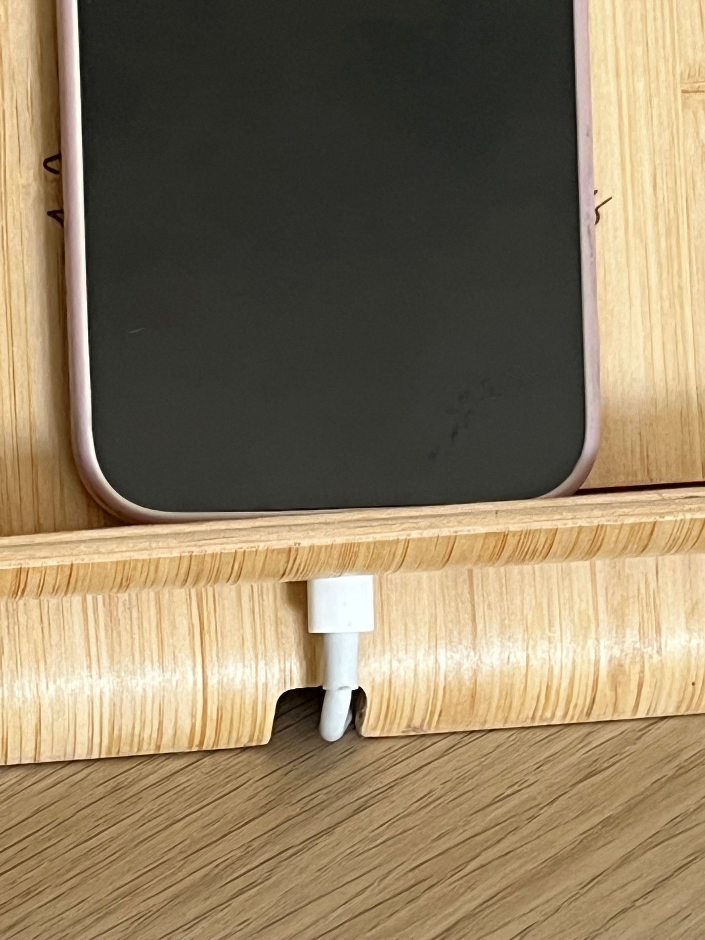 A unique personalised bamboo phone stand laser-engraved with a couple holding hands, two names & a date. Perfect wedding, anniversary or Valentine's gift.